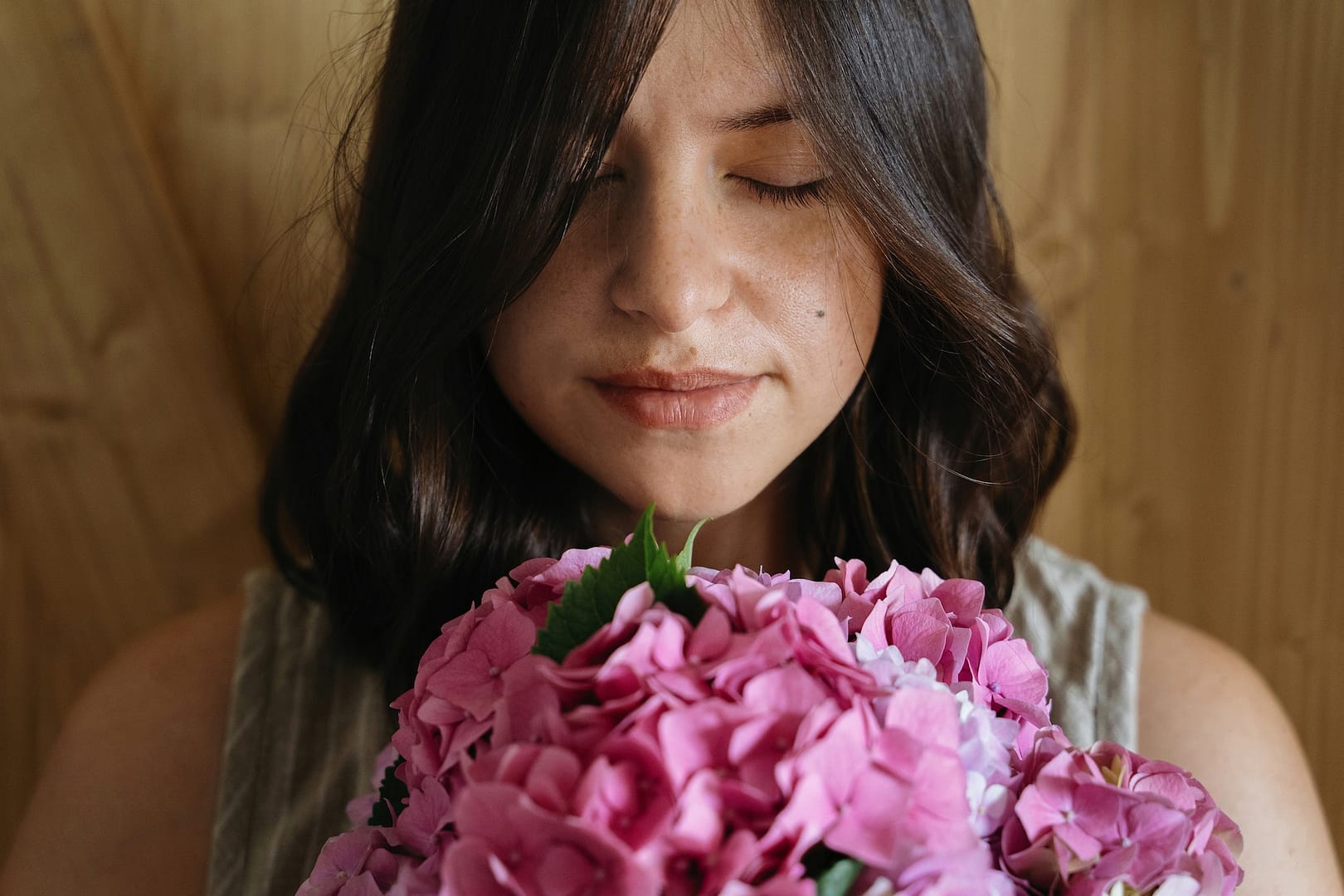 Young woman smelling beautiful hydrangea bouquet